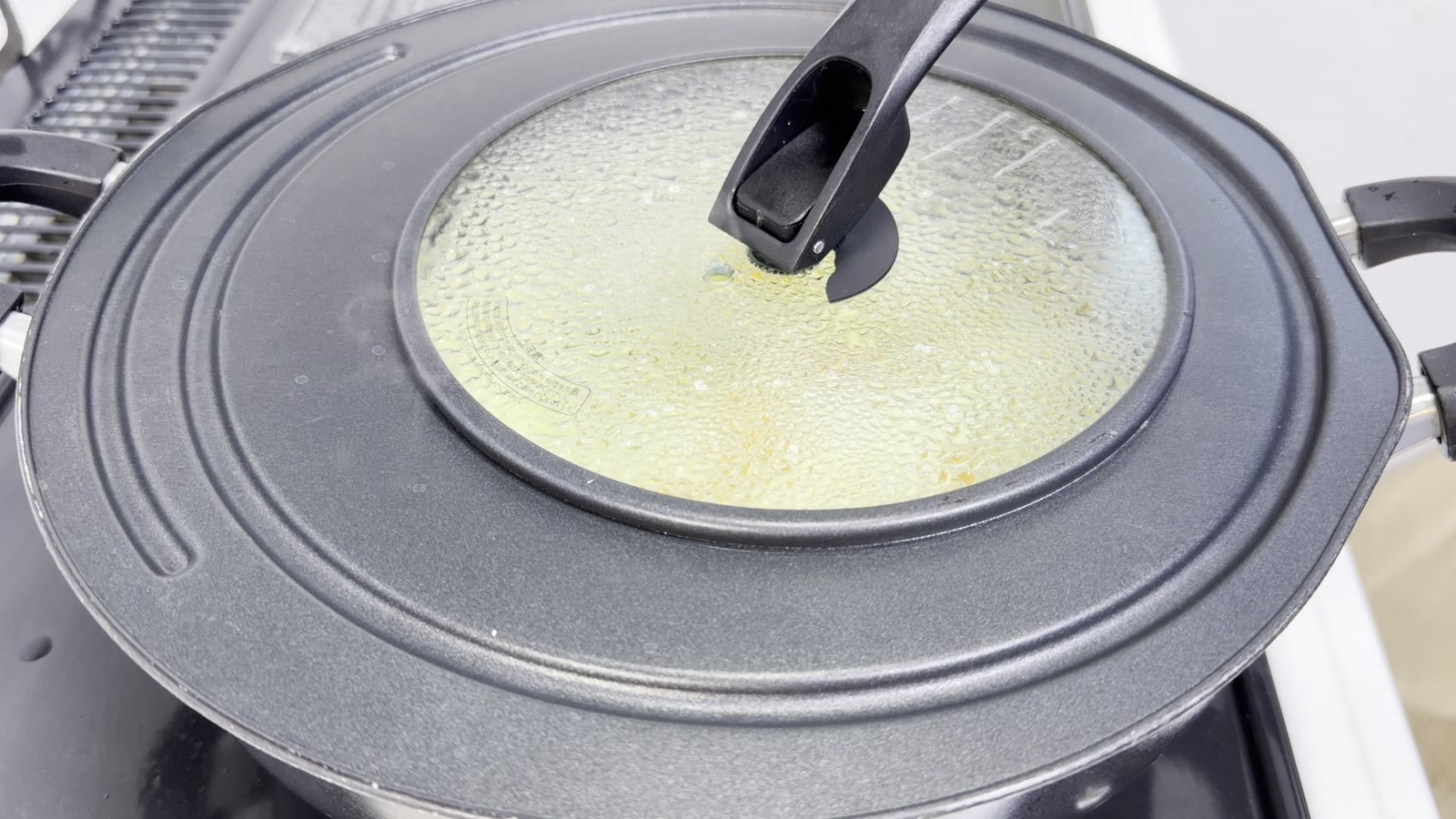 フライパンにふたをして野菜を蒸し焼きにする様子